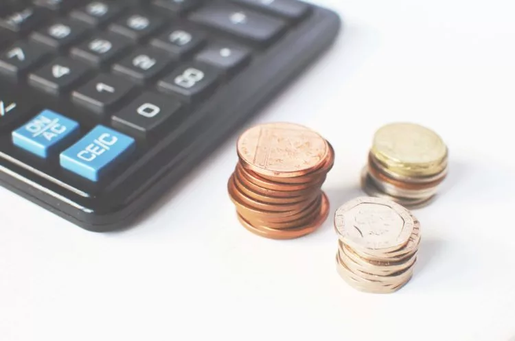 calculadora e moedas sobre um fundo
