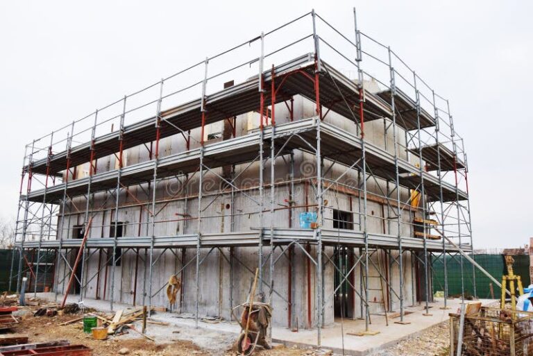 casa em construcao com andaimes e ferramentas
