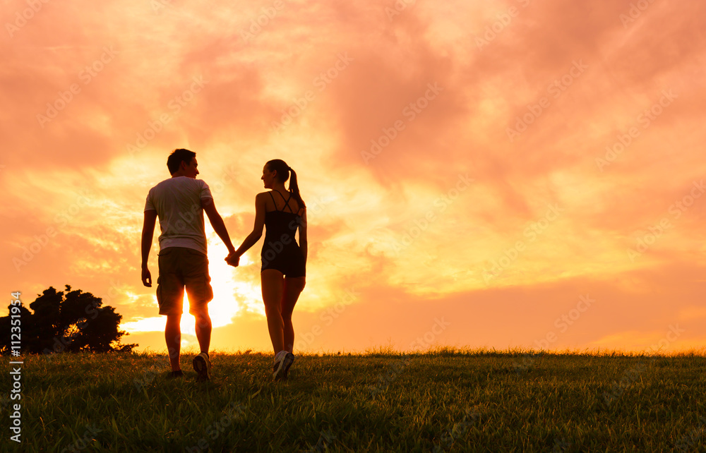 casal de maos dadas ao por do sol