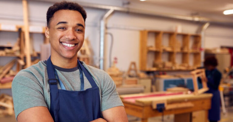 Até que idade é possível se inscrever no programa Jovem Aprendiz 15 jovem aprendiz sorrindo em ambiente de trabalho 1