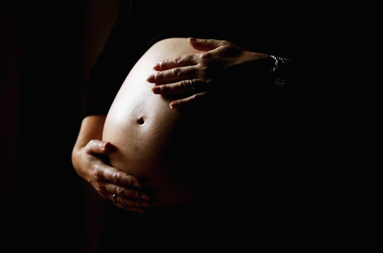 mae gravida segurando a barriga contente