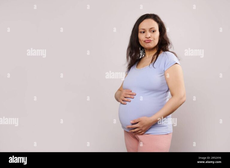 mae gravida segurando a barriga pensativa