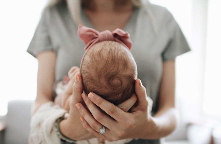 mae segurando bebe em ambiente acolhedor