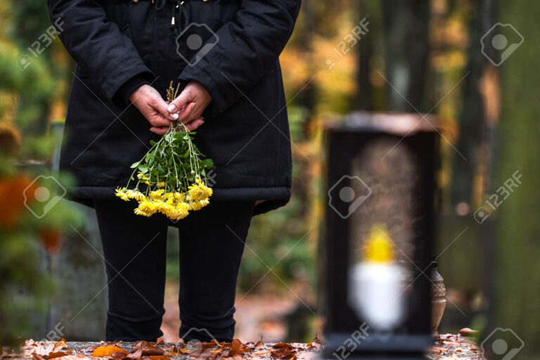 mao segurando flores em um cemiterio