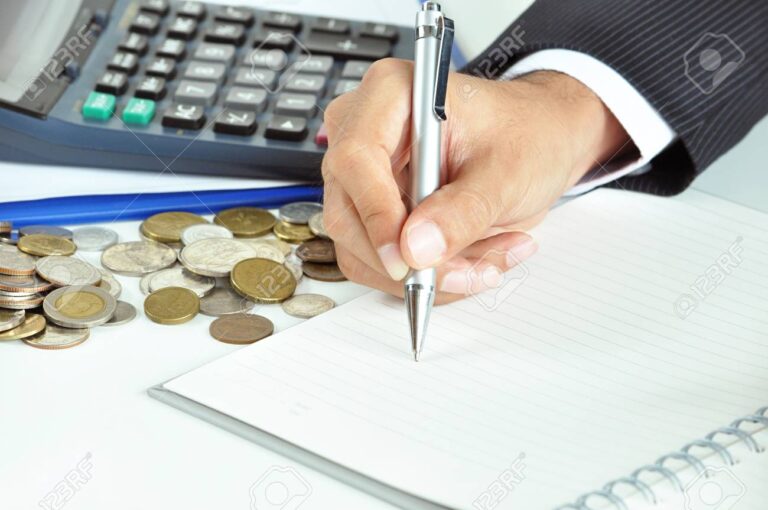 mao segurando moedas sobre um calculo financeiro