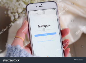 mao segurando um smartphone com instagram aberto