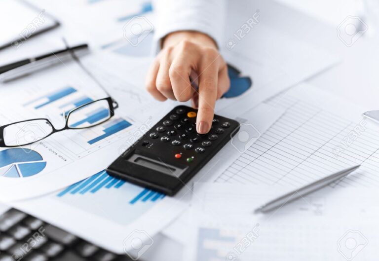 mao segurando uma calculadora e documentos
