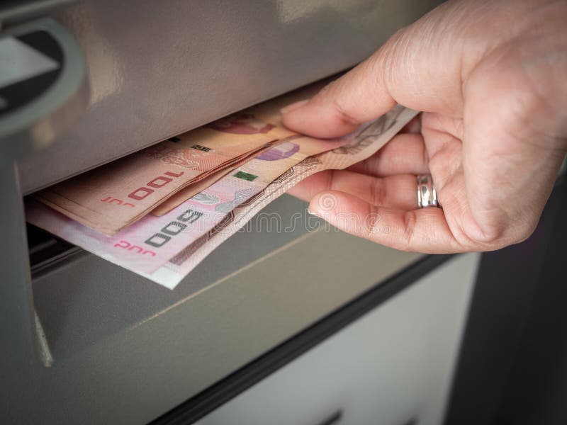 maos recebendo dinheiro em um caixa eletronico