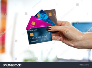 maos segurando cartoes de credito variados