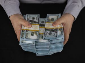 maos segurando dinheiro e um contracheque