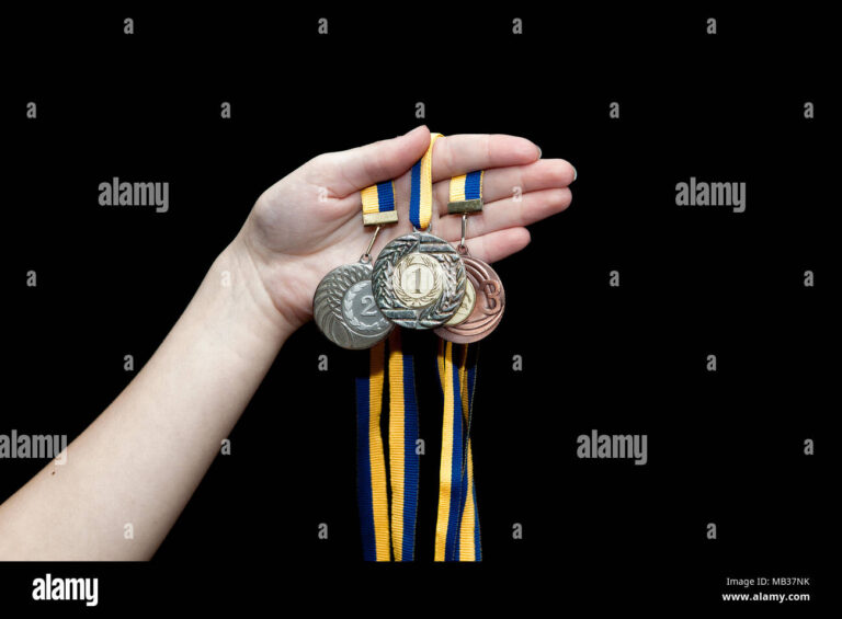 maos segurando medalhas de prata e ouro