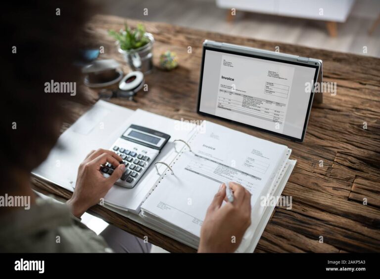 maos segurando um computador e notas fiscais