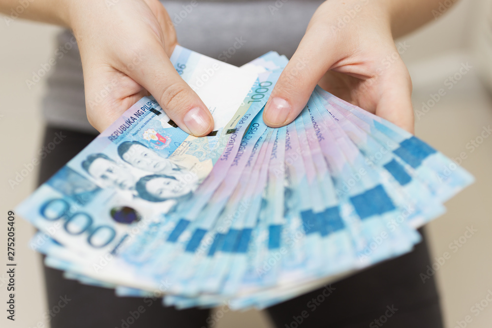 maos segurando um salario em dinheiro