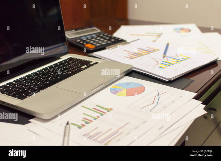 mesa com documentos e computador em uso