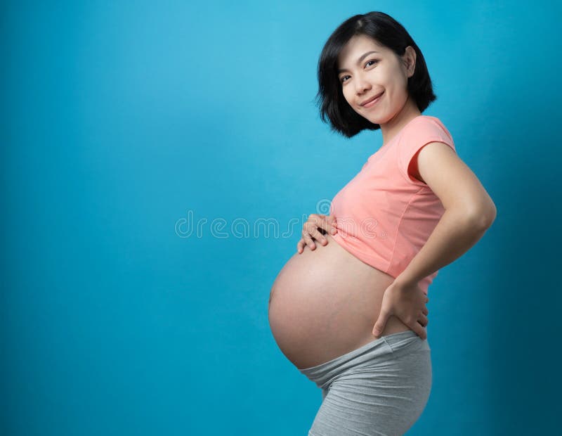 mulher gravida segurando a barriga sorridente
