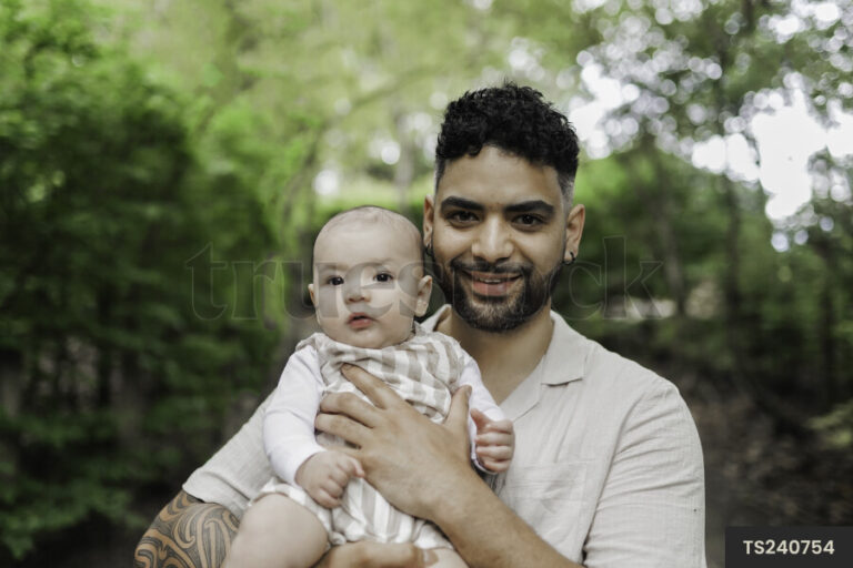 pai segurando bebe em um parque