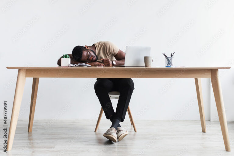 pessoa dormindo em mesa de escritorio