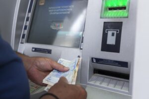pessoa recebendo dinheiro em caixa eletronico