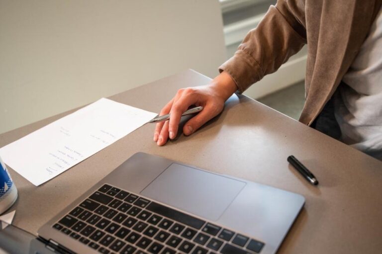 pessoa trabalhando com laptop e documentos