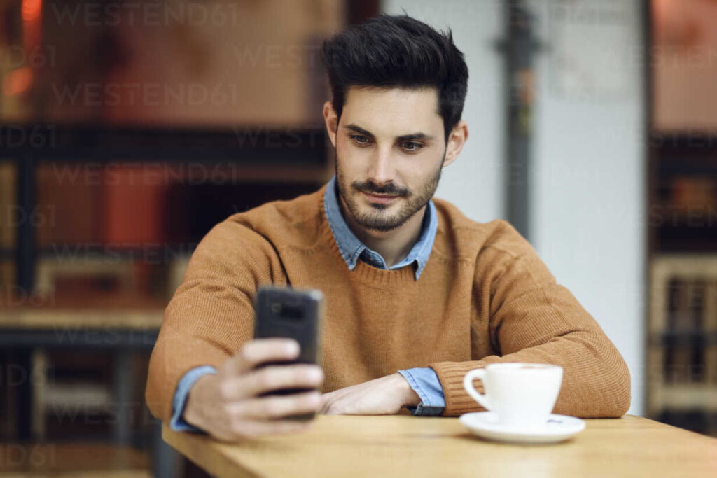 pessoa usando celular em um cafe