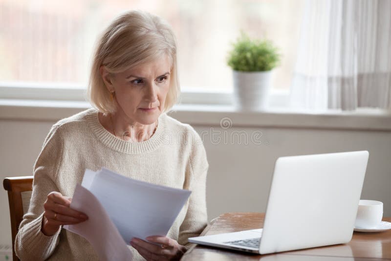 pessoa verificando documentos em um computador