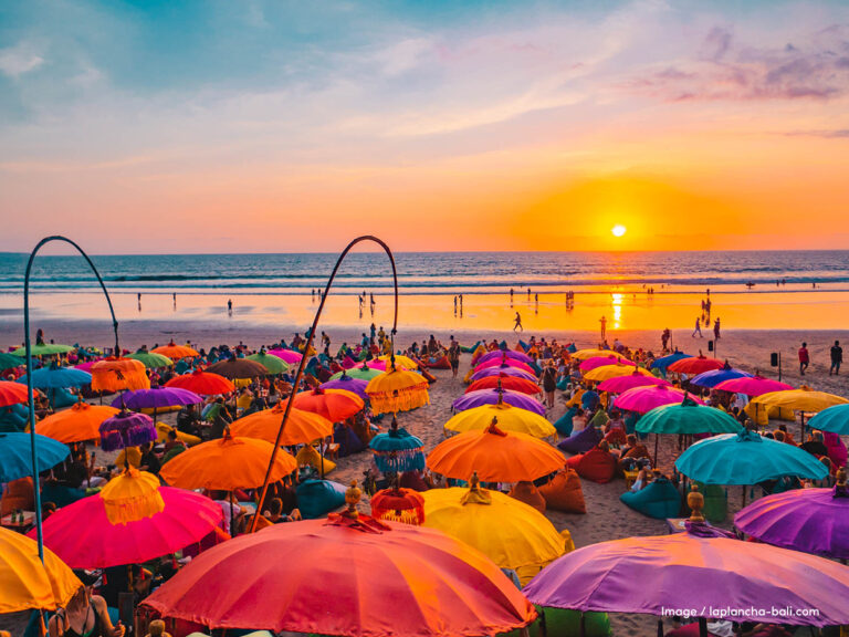 praia ao por do sol com guarda sois