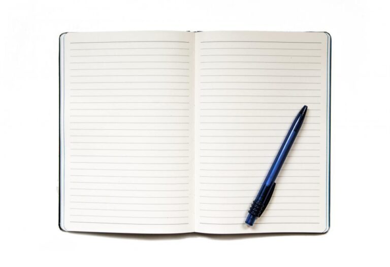 uma caneta e um caderno abertos